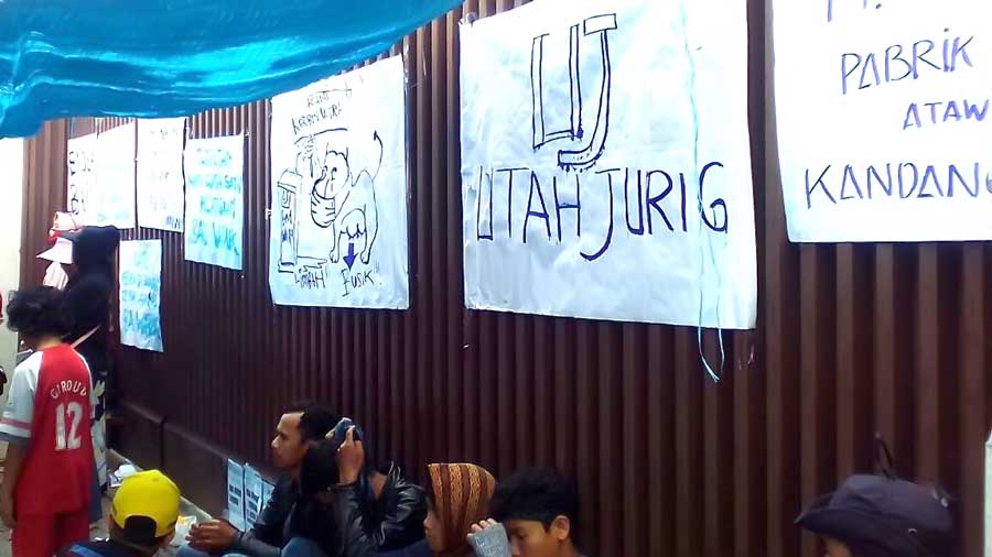 Sejumlah poster mewarnai aksi demo warga Desa Gadobangkong di depan PT. Ultra Jaya, belum lama ini.