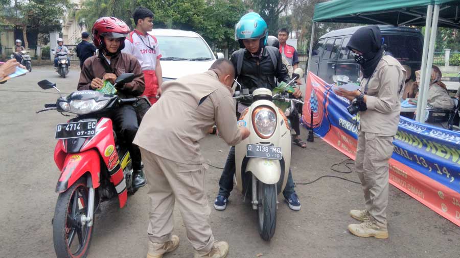 Petugas Dinas Lingkungan Hidup Kota Cimahi melakukan uji emisi kendaraan bermotor  