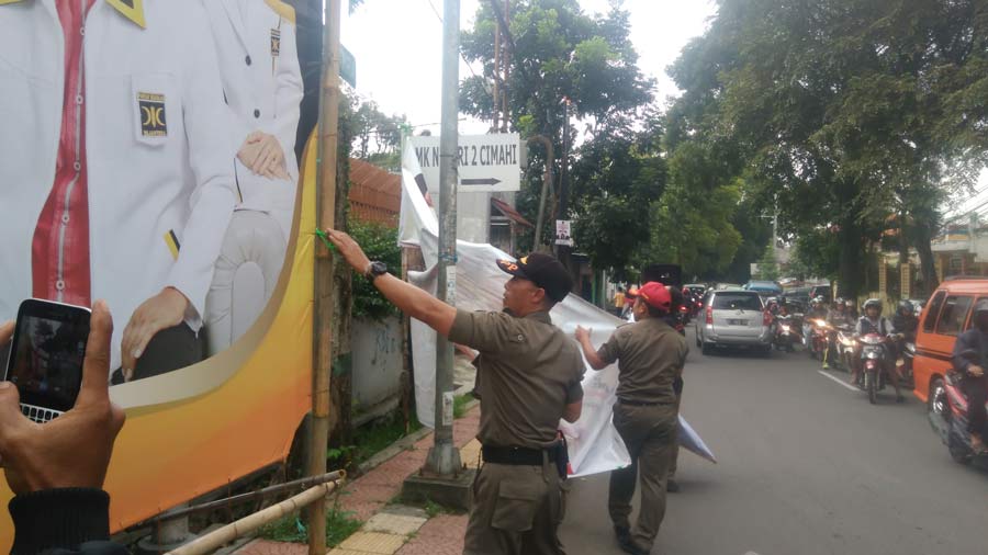 Panwaslu dan Satpol PP menertibkan propaganda politik di Jalan umum Kota Cimahi.