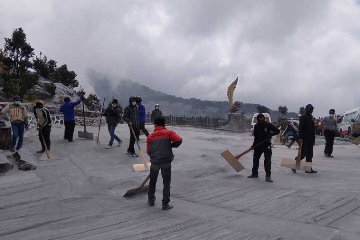 Warga sedang Membersihkan debu sisa erupsi Gunung Tangkuban Parahu