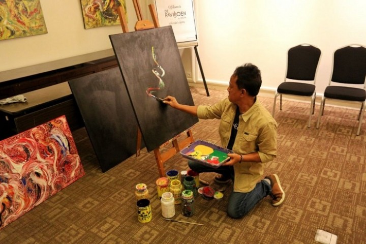 Pelukis Heru Prayoga menggoreskan kuas di kanvas saat pameran di Hotel De’Paviljoen, Jalan Riau, Bandung, Selasa (12/5). 