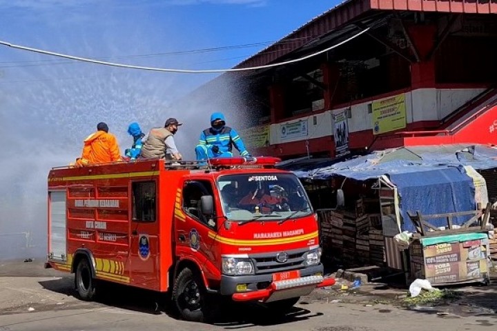 Petugas Pemadam Kebakaran menyemprotkan cairan disinfectan di Pasar Antri Baru.