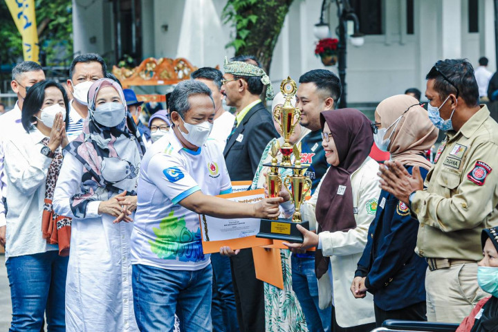 Wali Kota Bandung Yana Mulyana menyerahkan piala kegiatan HKSN, Sabtu (24/12/2022)