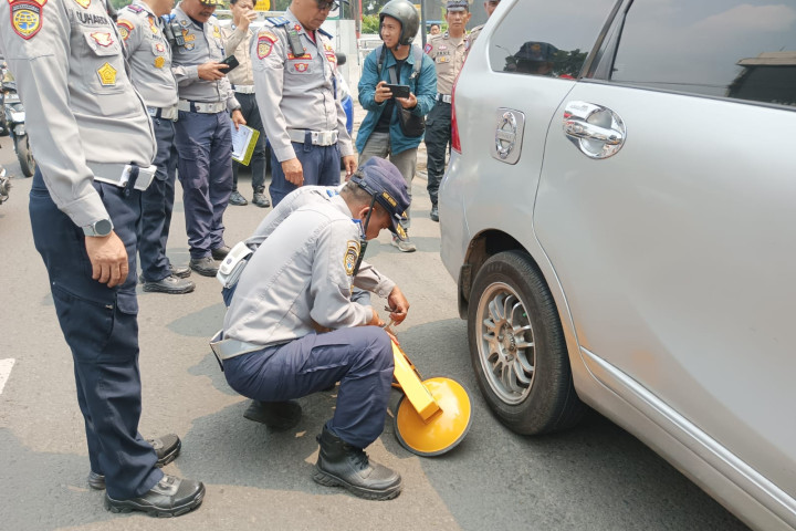 Petugas Dishub Kota Cimahi melakukan sanksi penggembokan kendaraan yang parkir di tempat terlarang, Kamis, 25 September 2025. 