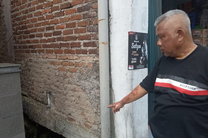 Warga RW 05 Kelurahan Cibabat menunjukan lokasi selokan tempat pembuangan limbah domestik, Senin, 6 Oktober 2025.