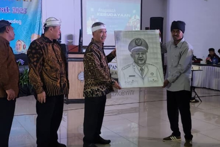 Wakil Bupati Bandung Barat Asep Ismail menerima Lukisan dari salah seorang seniman saat pelaksanaan  Anugerah Kebudayaan Kabupaten Bandung Barat 2025 di Grand Panorama Lembang.