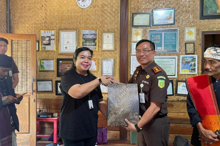 Kepala Kejaksaan Negeri Cimahi Nurintan Marolop Novianti Octaviana Sirait, S.H., M.H, memberikan cinderamata kepada Rombongan  Tim Studi Tiru PAKEM Kabupaten Toba, di Kampung Adat Cireundeu, Jum’at, 5 Desember 2025.  