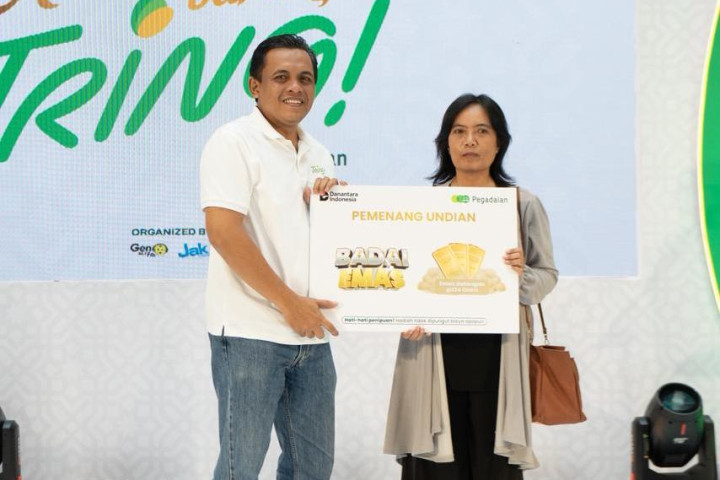 Pemimpin Wilayah Pegadaian Kanwil X Jawa Barat Eko Supriyanto menyerahkan hadiah utama emas batangan 124 gram kepada Yenny Mulyani, nasabah dari Pegadaian UPC Dago dalam rangkaian kegiatan Ramadan Bareng TRING! 