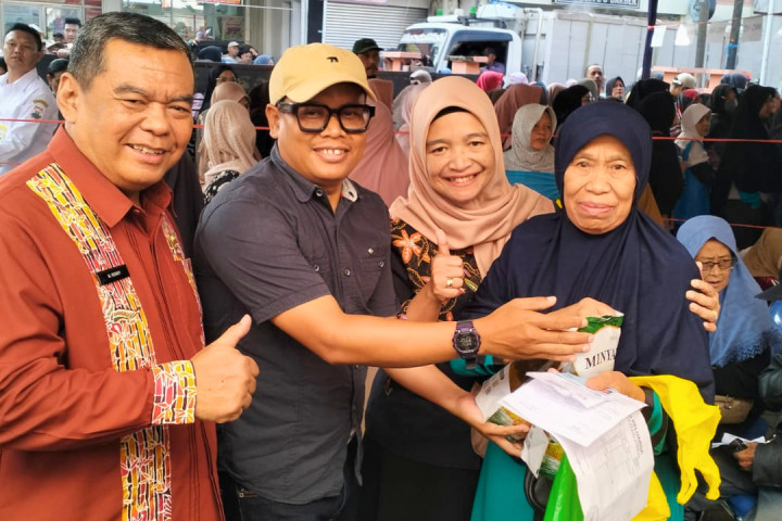 Asisten Administrasi Umum Setda Kota Cimahi, Mohammad Ronny bersama perwakilan Bulog menyerahkan bantuan cadangan pangan pemerintah kepada warga yang membutuhkan, Jum'at, 10 April 2026.