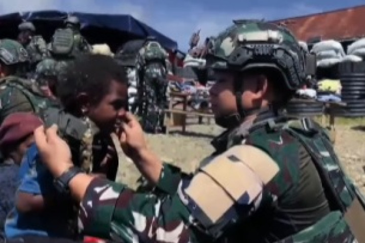 Personel TNI dari Satgas Yonif 136/Tuah Sakti memberikan pakaian layak pakai kepada salah seorang anak warga Kampung Dinggok, Kabupaten Puncak Jaya, Papua Tengah