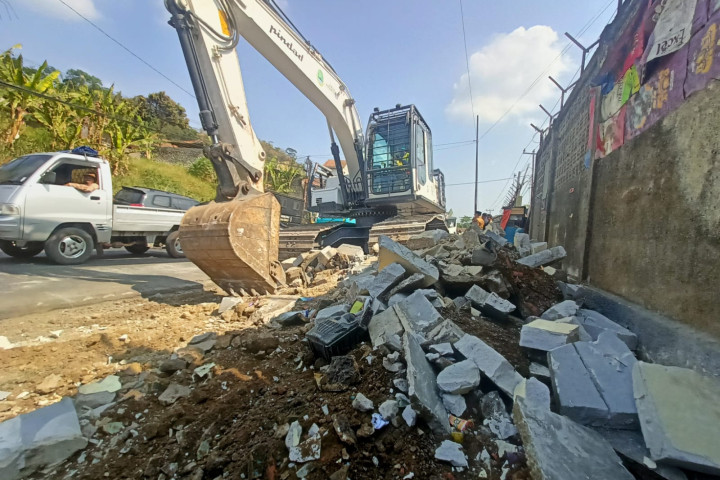 Foto: Alat berat diturunkan untuk membongkar bangunan liar yang berdiri di Ruang Milik Jalan (Rumija) di Jalan Raya Purwakarta–Bandung, Desa Tagog Apu, Kecamatan Padalarang, Kabupaten Bandung Barat, Selasa (21/7/2026). 