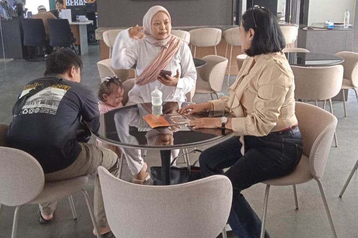 Marketing Hunian Warisan Bangsa (HWB) Kiky Triwidya sedang melayani konsumen perumahan.