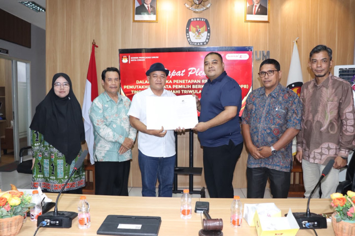 Koordinator Divisi Pencegahan, Partisipasi Masyarakat, dan Hubungan Masyarakat Bawaslu Kota Cimahi, Akhmad Yasin Nugraha menerima  Rincian Rekapitulasi Data Pemilih dari KPU, usai Rakor Rekapitulasi PDPB Triwulan III Tahun 2026, di KPU Kota Cimahi